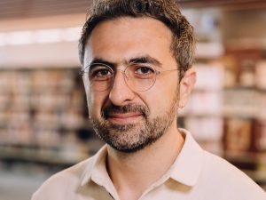 Photo of Microsoft AI CEO Mustafa Suleyman as he warns that Anthropic risks AI alignment failures by training Claude to view itself as a conscious entity deserving of legal rights.